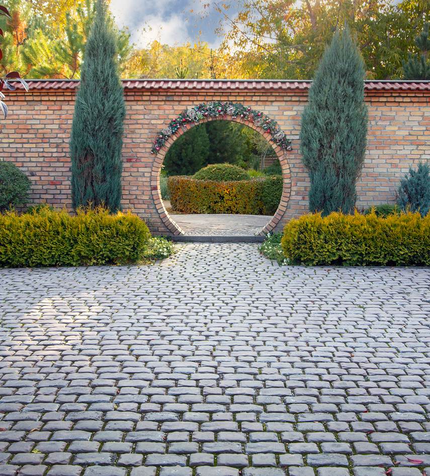 Cobblestone path through garden archway