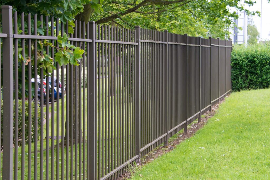 Metal fence alongside green grass