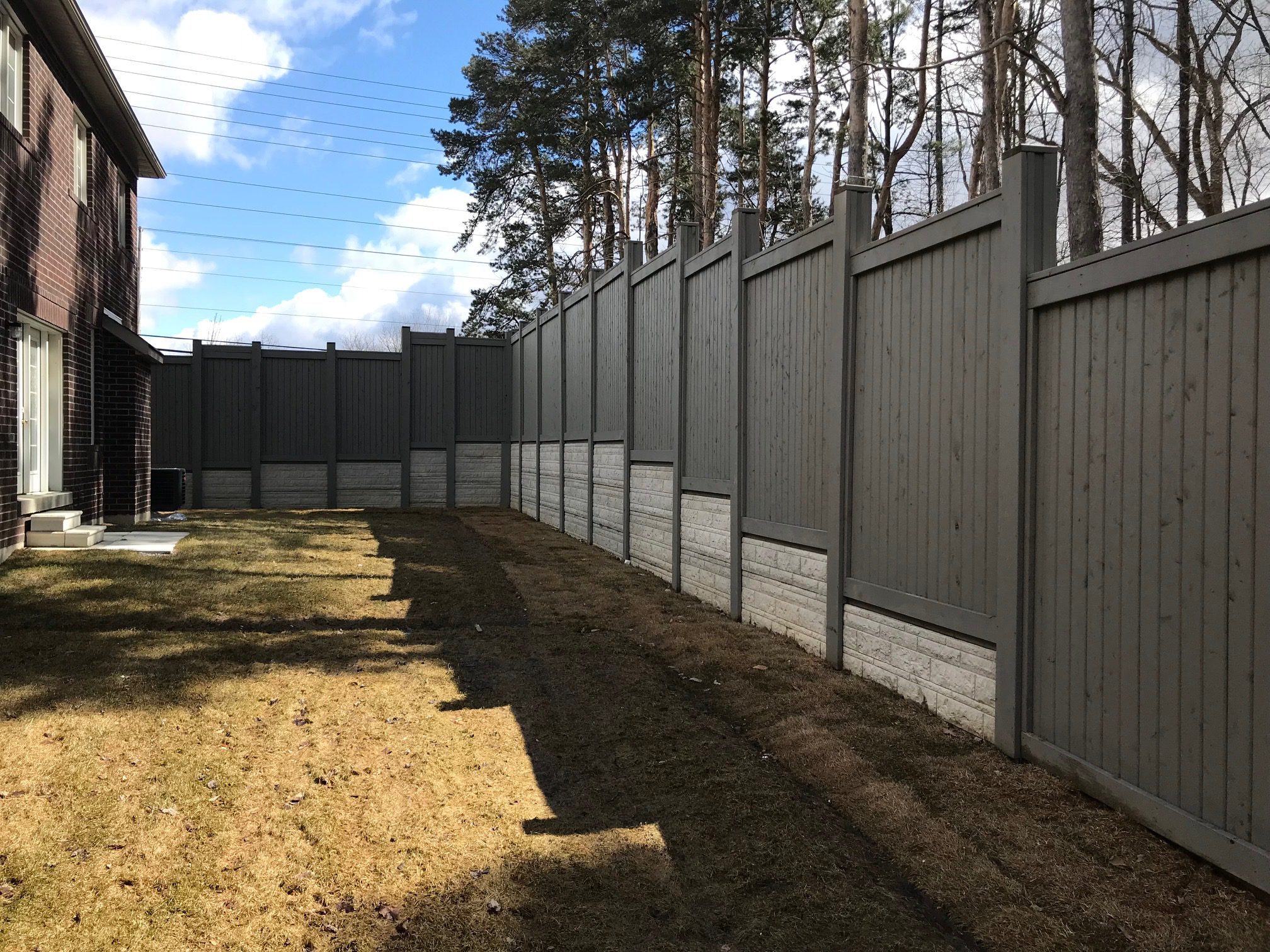 Backyard with tall gray privacy fence