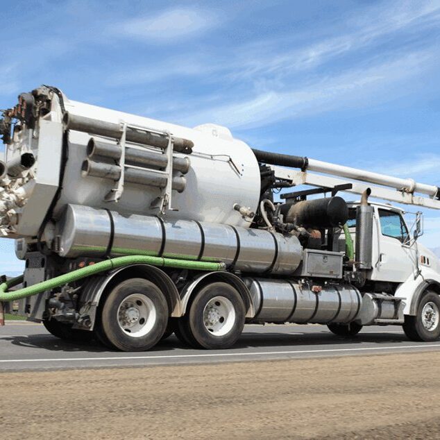 White vacuum truck driving on highway